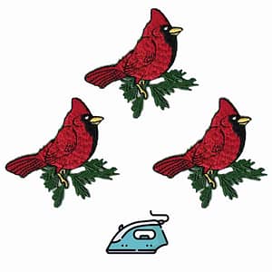 Four Cardinal on Branch Patches (3 Pack) Bird Embroidered Iron On Patch Appliques on an ironing board.