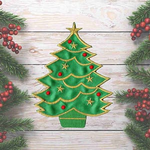 A Christmas Tree Holiday Iron On Patch embroidered on a wooden background.