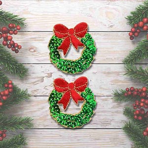 Two Sequined Wreath Patches (2-Pack) Christmas Embroidered Iron On Patch Applique on a wooden background.