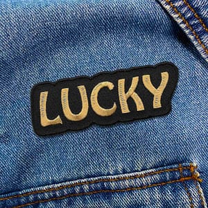 A Lucky Iron On Patch with the word lucky on it.