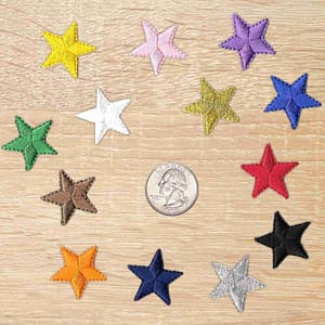 A group of 1 Inch Star Iron On Patch (10 Pack) appliques on a wooden table.
