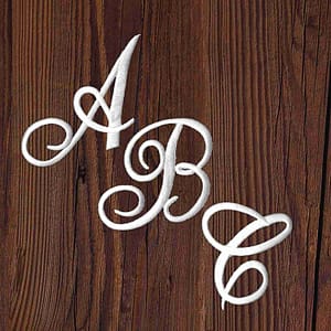 The Iron On Script Letter Patches, Monogram Appliques abc and c on a wooden surface.