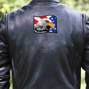 The back of a man wearing a leather jacket with a Bald Eagle Head with American Flag (2-Pack) Iron On Patch on it.