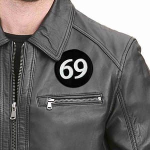 A man wearing a leather jacket with the 69 Embroidered Iron On Patch - 3" Round on it.