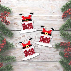 Three Santa Stuck in Chimney Patches (3-Pack) Christmas Iron On Patch Appliques on a wooden background.