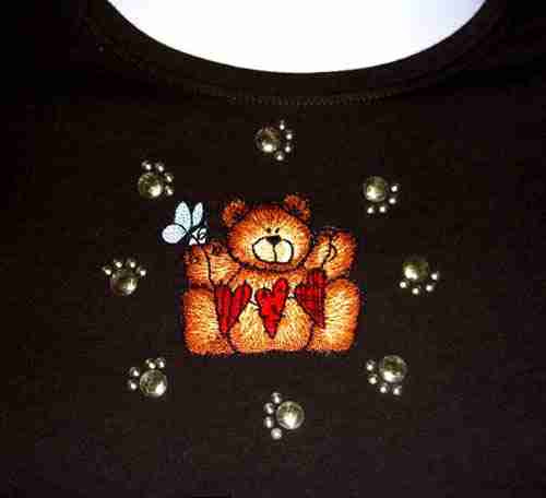 A black t-shirt with the Animal Paw Prints Iron on Hotfix Applique: Black on it.