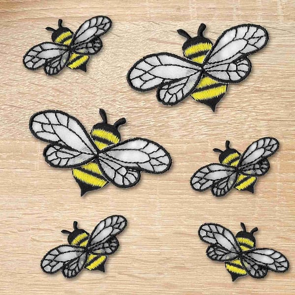 Embroidered Bee Patches with Chiffon Wings (5 Pack) Insect Embroidered Iron on Patch Appliques on a wooden table.