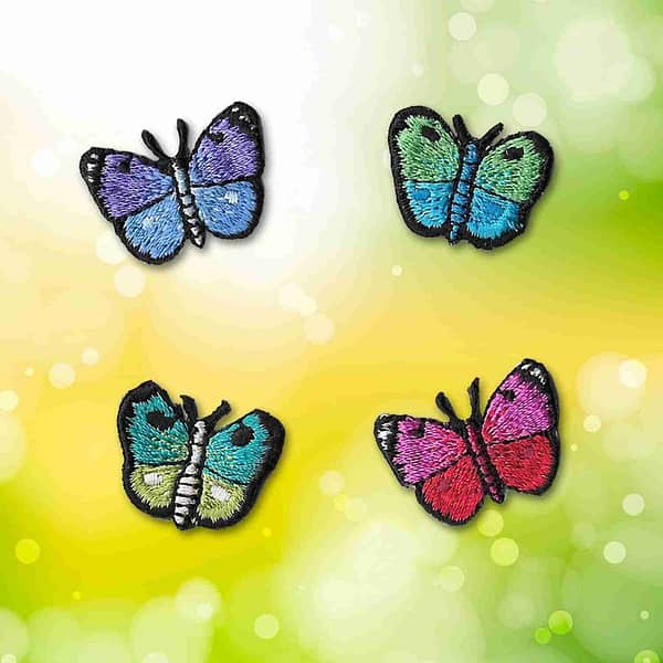 Four tiny butterfly iron on patches: multiple colors on a green background.