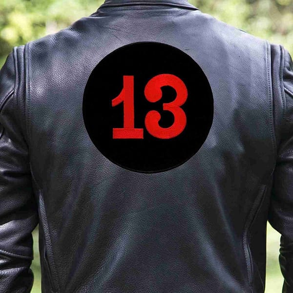 The back of a man wearing a leather jacket with the Number 13 Back Patch On Embroidered Iron or Patch- 7 1/2 inch Round on it.