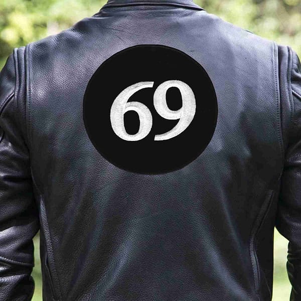 A man wearing a 69 Back Patch Embroidered Iron On Patch - Large on his leather jacket.