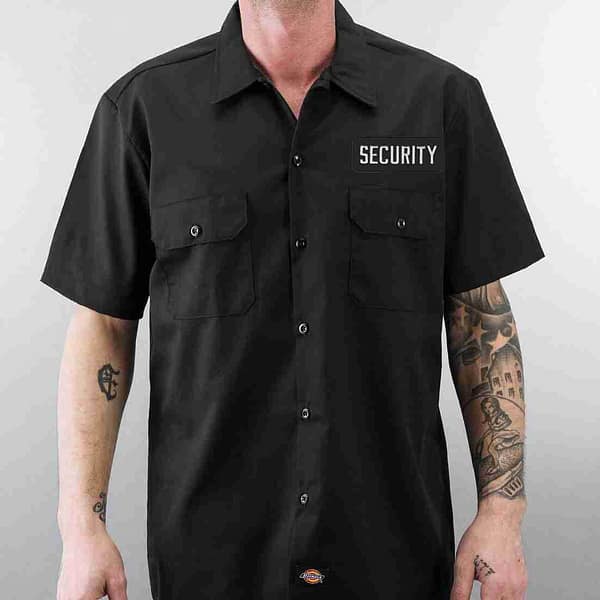 A man wearing a black shirt with the Security Patches (2-Pack) SECURITY Embroidered Iron on Patch Applique - Sleeve Tag on it.