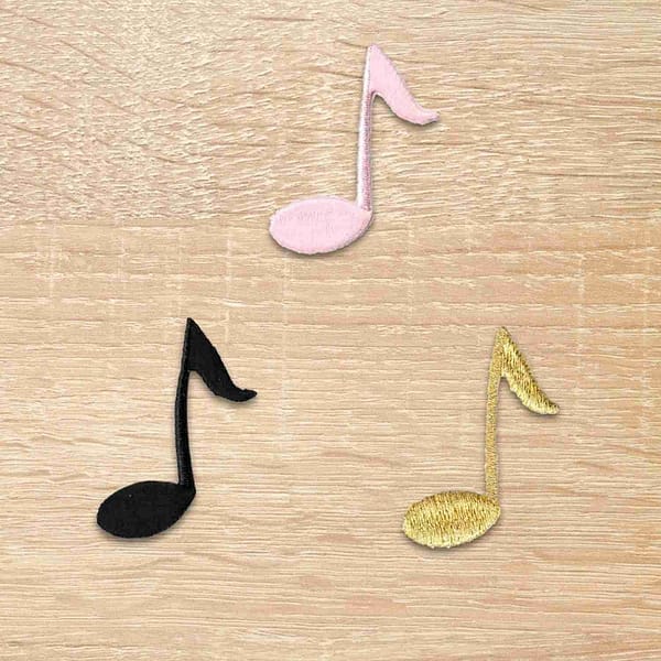 Three Eighth Note Musical Patches (10 Pack) on a wooden surface.