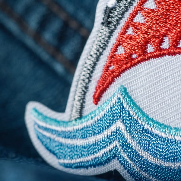 A Shark Attack Patch (2-Pack) on a pair of jeans.
