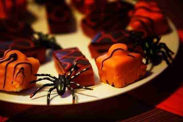 A plate of halloween desserts with spiders on it.