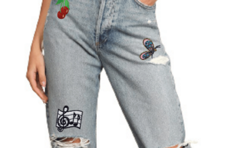 A woman wearing ripped jeans with embroidered patches.